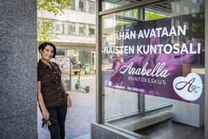 Midia hymyilee uuden Anabellan edustalla, takana näkyy Tampereen Kuninkaankatu.
